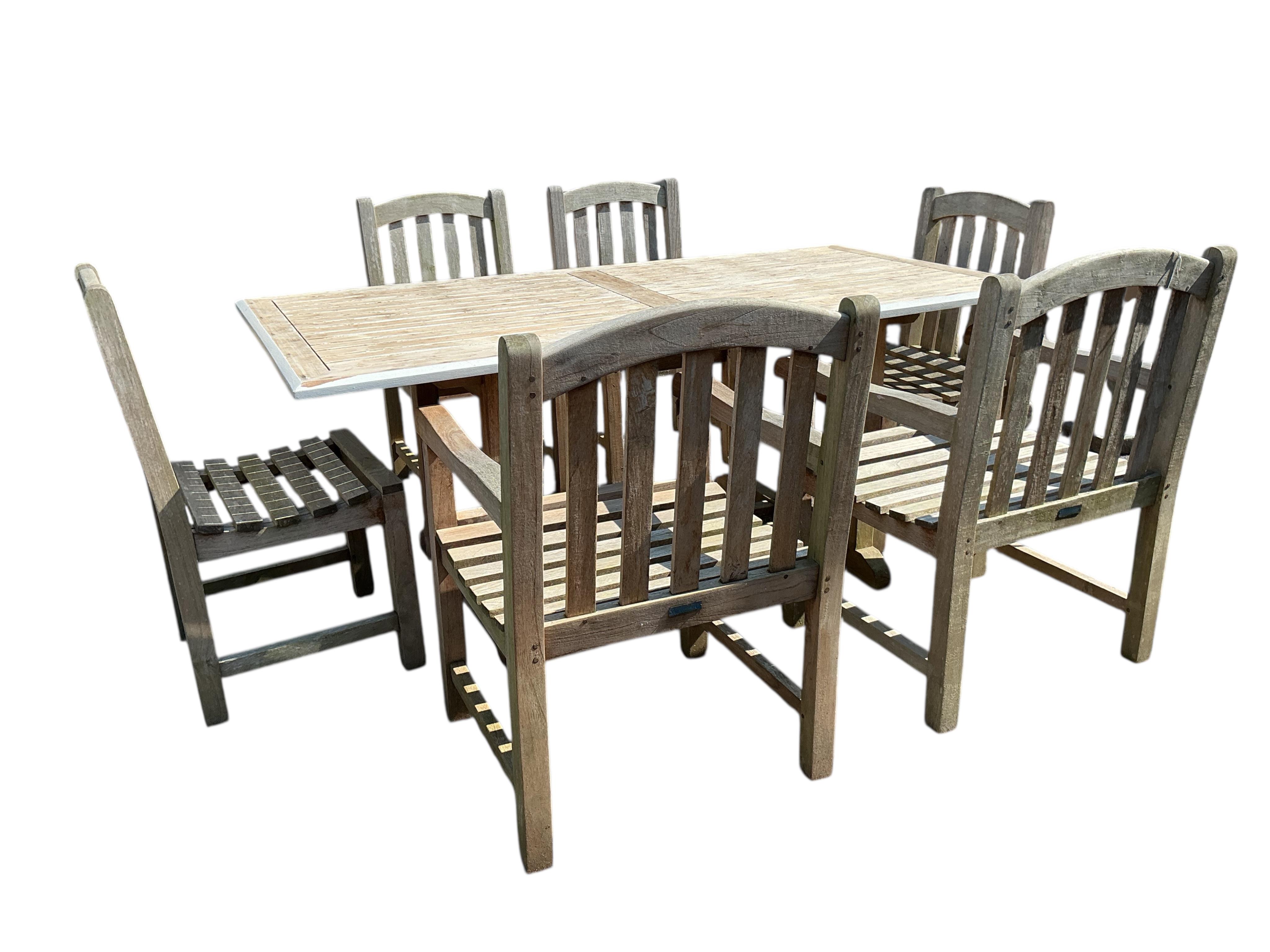 A rectangular weathered teak garden table, width 180cm, depth 90cm, height 75cm and six Lindsey weathered teak garden chairs, two with arms